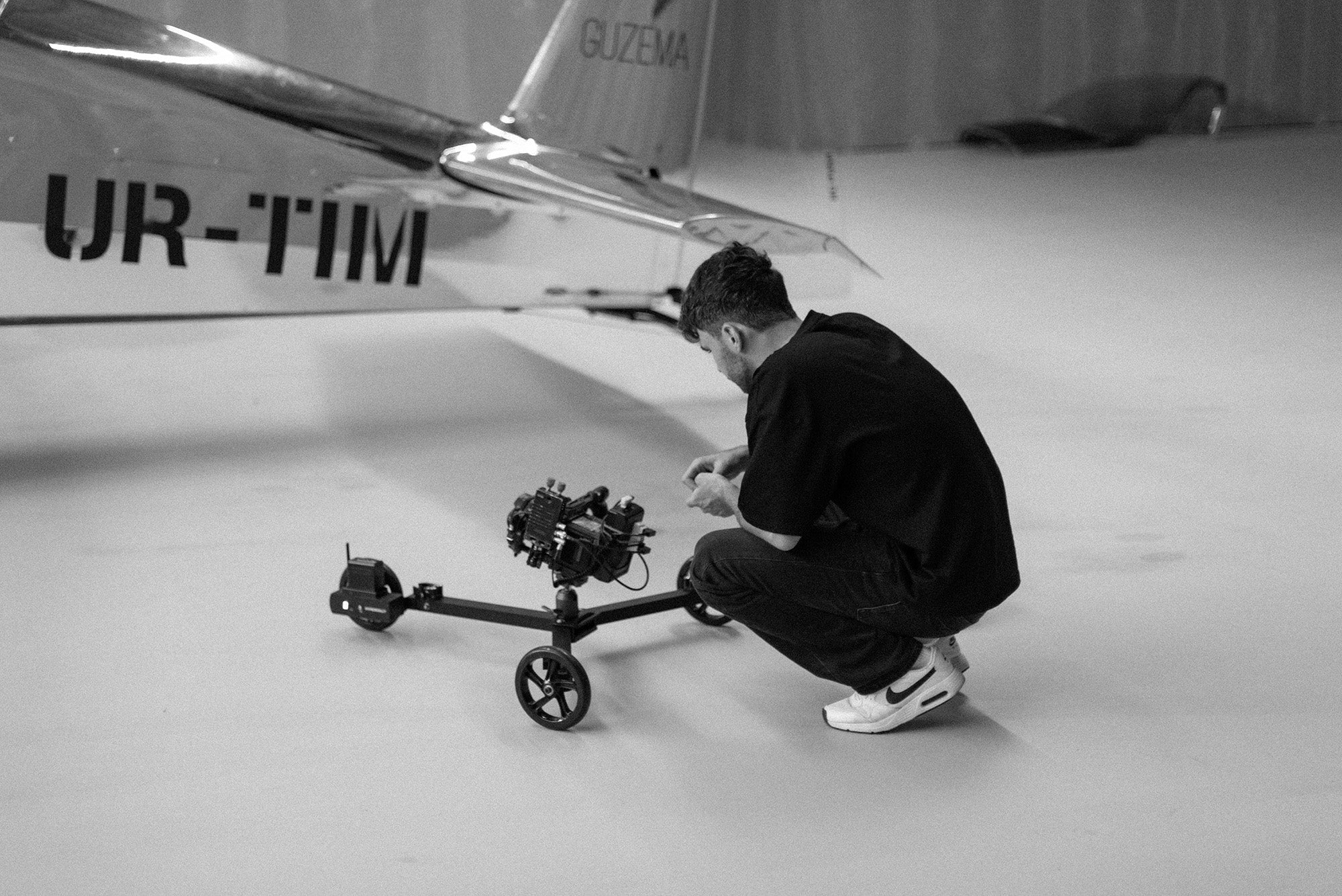 Backstage view of Hyperdolly founder Andrii Statieva filming aircraft in a hangar using the HY-01 motorized dolly.